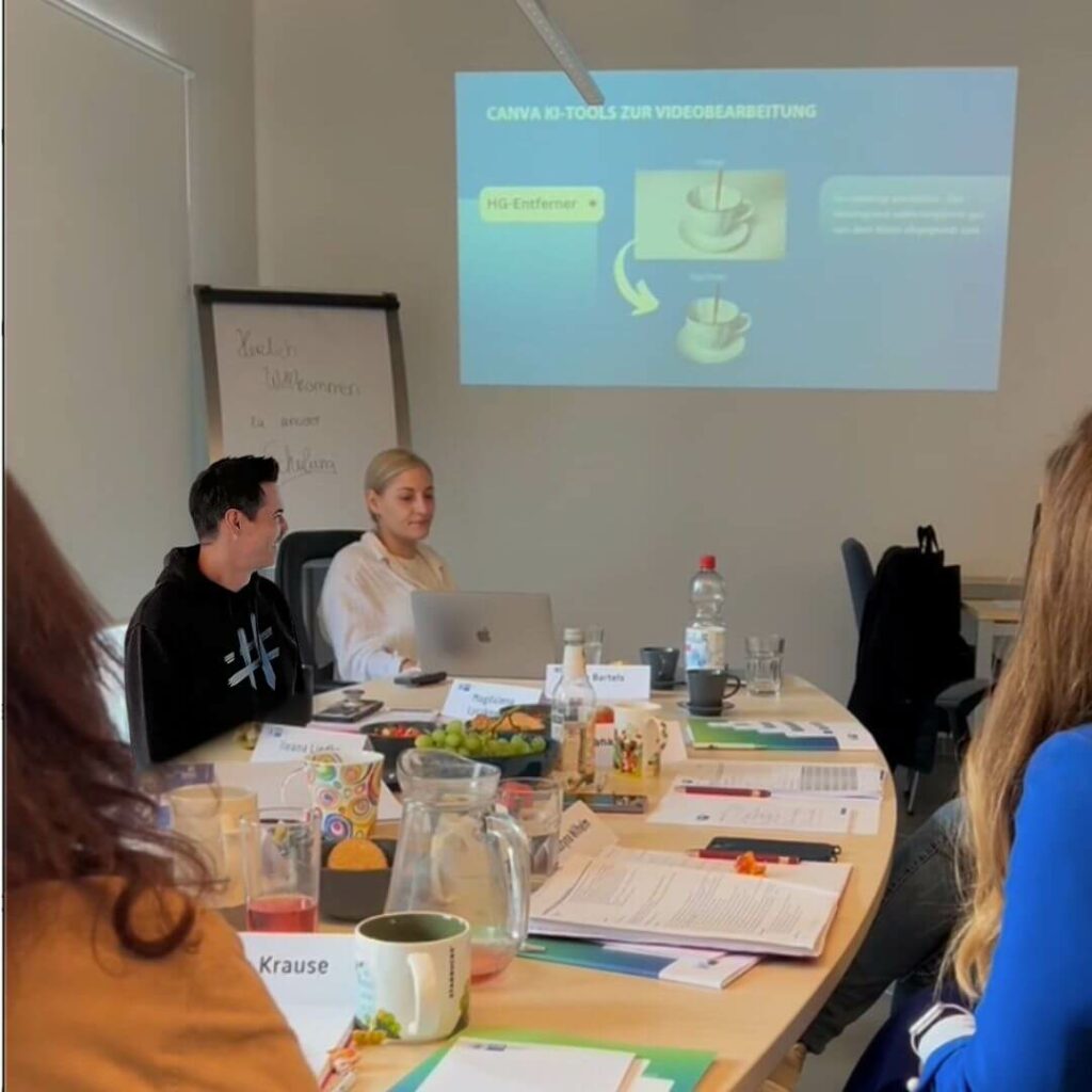 Ingo Bartels und Vanessa Broistedt erklären KI anhand einer Präsentation. Die Teilnehmenden sitzen am Tisch und schauen auf den Beamer